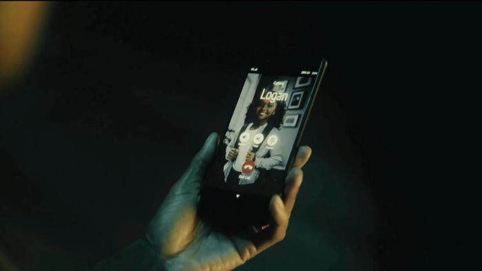 Alan Wake 2: hand holding a phone, receiving a phone call from "Logan"