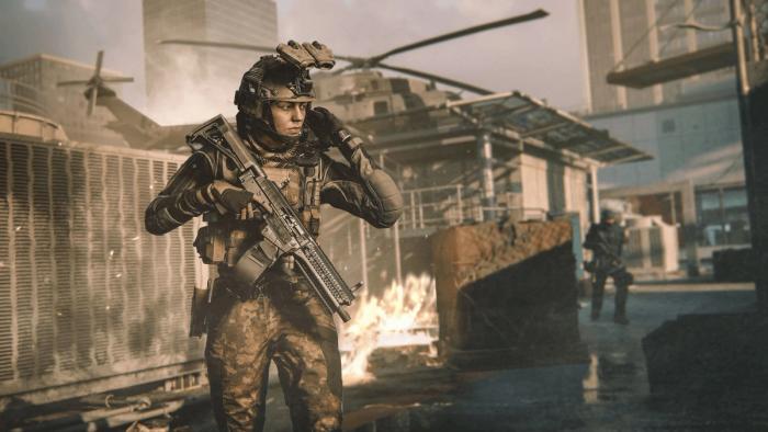 Modern Warfare 3 player raising hand to helmet with opponent and care package in background