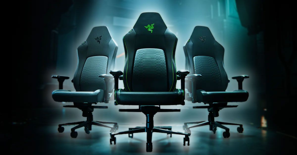 Three black gaming chairs lit up in in a dark room, all of which feature Razer branding in different colors at the top.