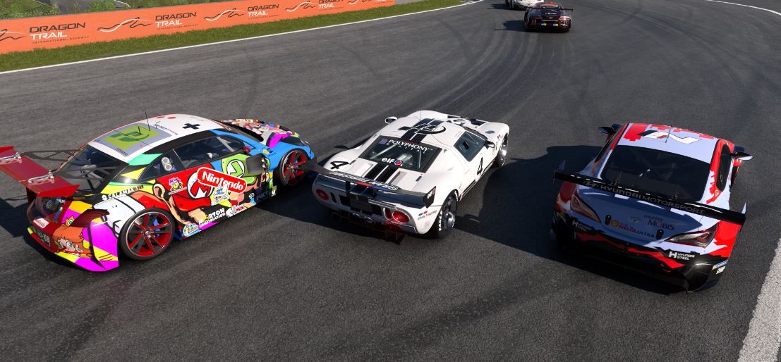 three racing cars are racing on a race track .