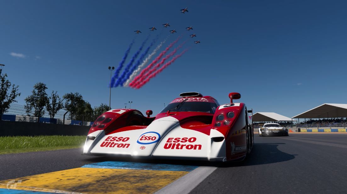 The GT-One driving under a french flag fly over in Gran Turismo 7