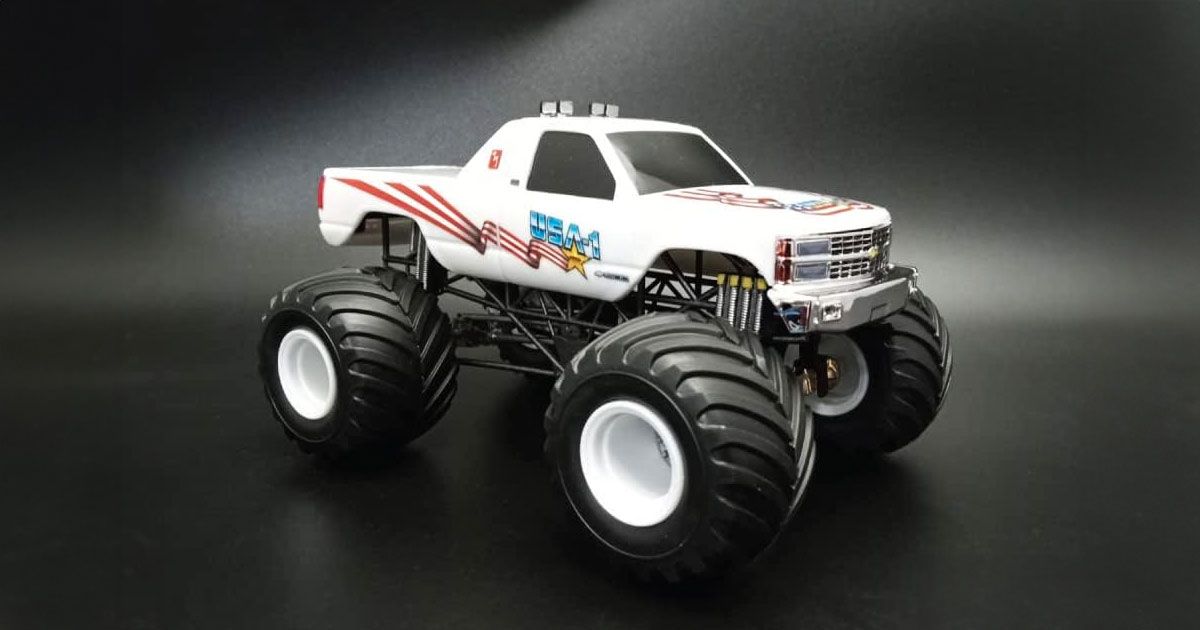 A white USA-branded monster truck model featuring red stripes down the side and huge wheels.