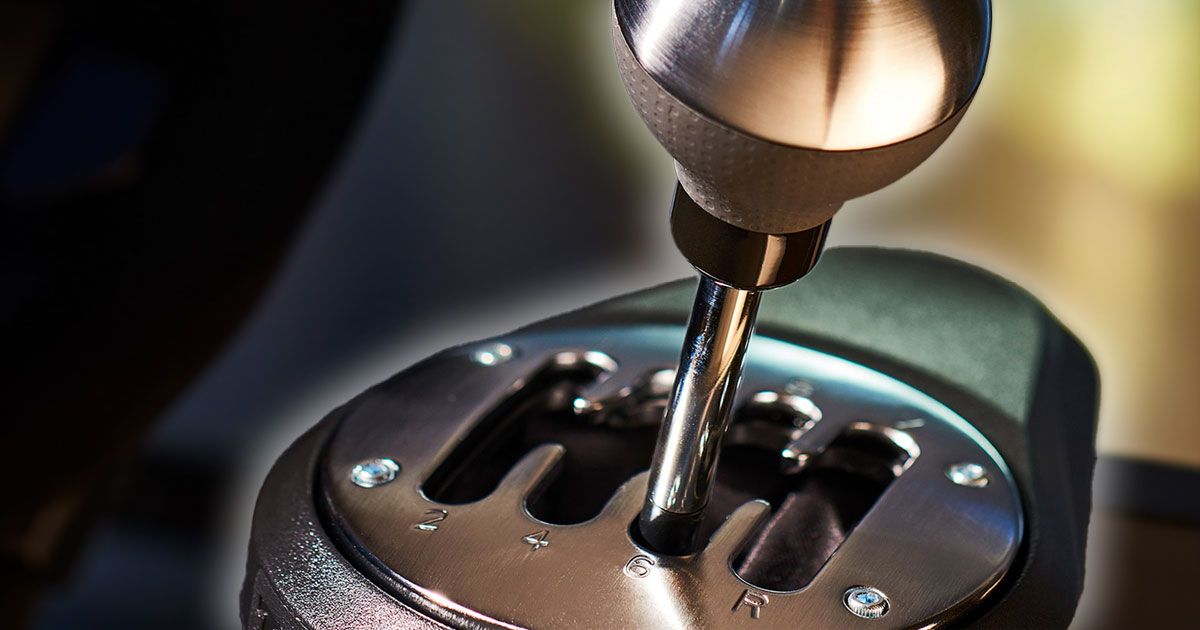 A close up of a silver gear shifter with black trim and a white glow around it.