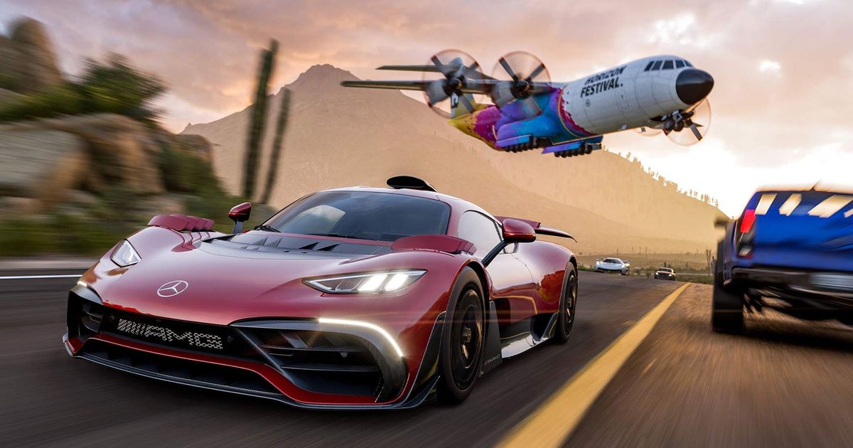 a red sports car is driving down a road with a plane flying overhead .