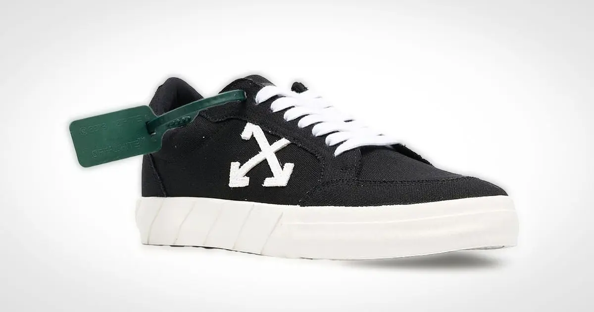 A black canvas shoe featuring white Off-White branding on the side to match the laces and a dark green lace tag.