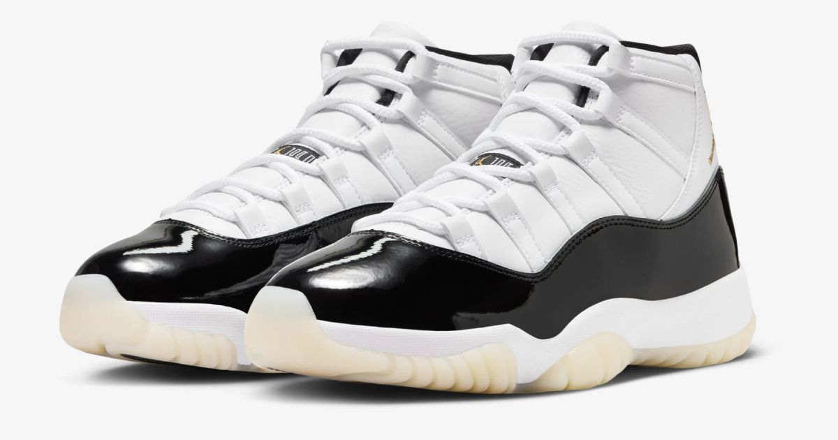 A pair of black and white Air Jordan 11 sneakers featuring cream outsoles.