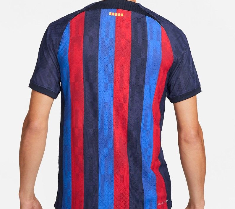 Barcelona home kit 2022/23 render image of a dark blue shirt with red and lighter blue stripes.