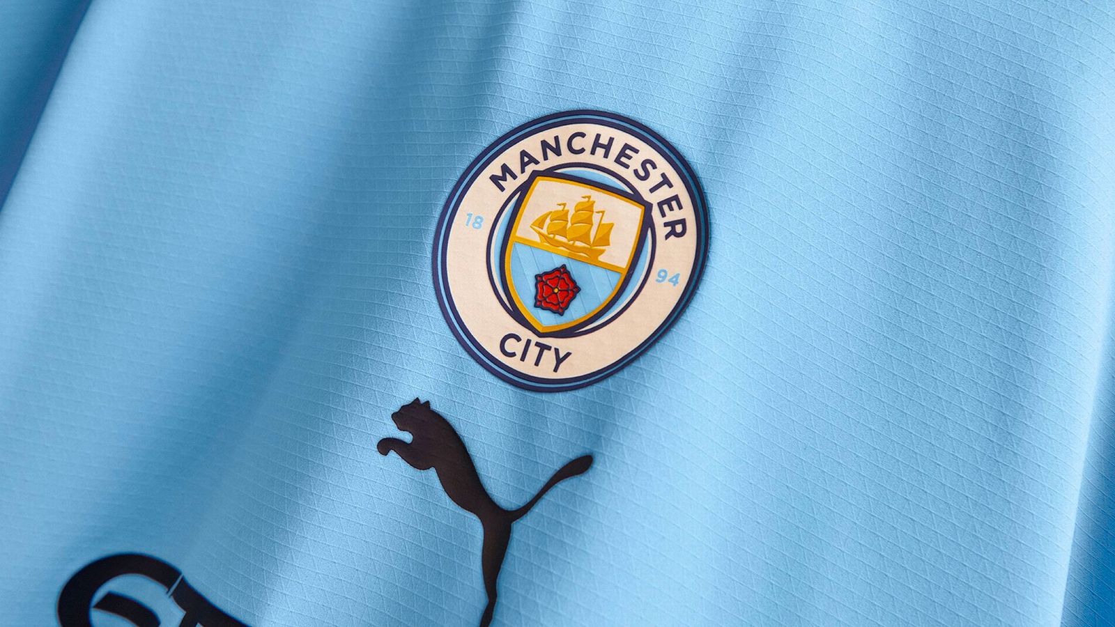 Manchester City home kit 2022/23 product image of a sky blue shirt with hints of maroon and white around the collar and sleeves.