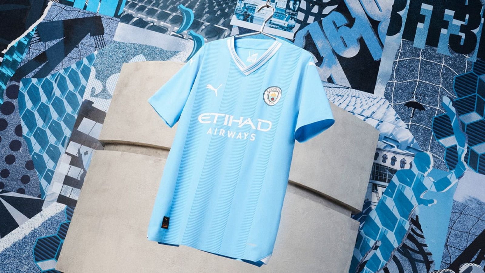 Manchester City PUMA Home Kit product image of a light blue jersey featuring a white collar hanging up.