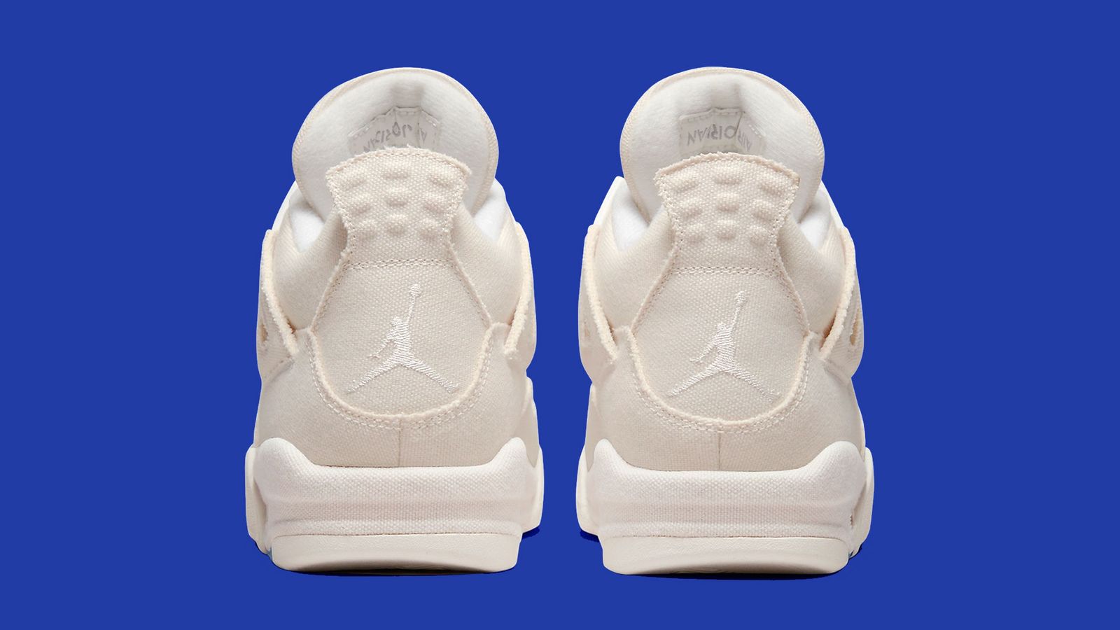 Air Jordan 4 "Blank Canvas" product image of an all-sail pair of sneakers with red and blue details.