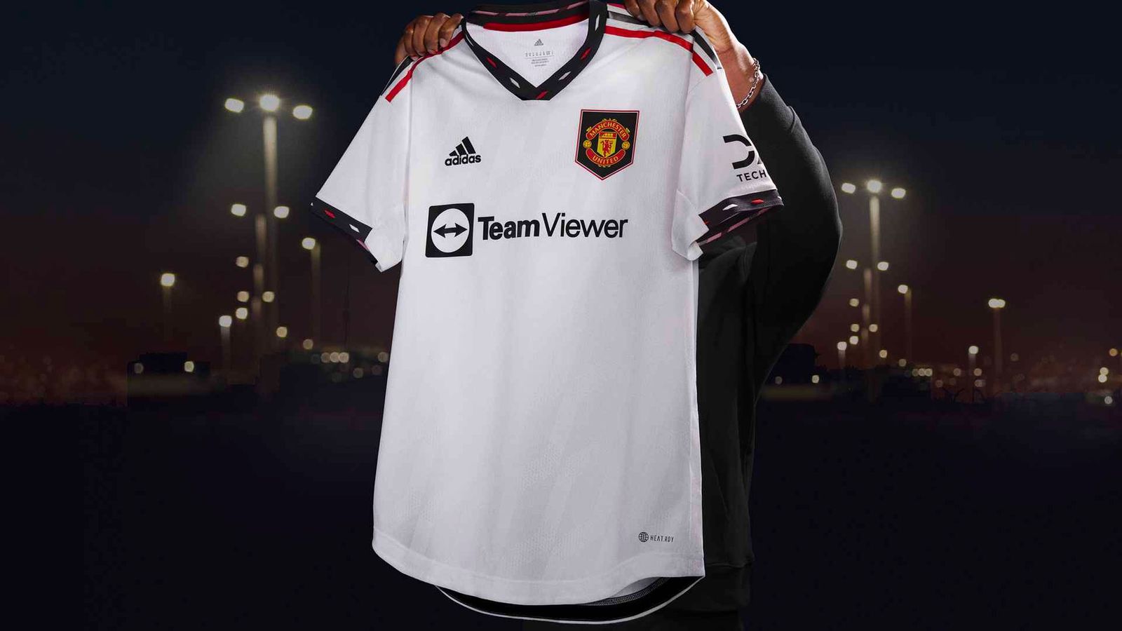 Manchester United away kit product image of a white shirt with black accents and red details.