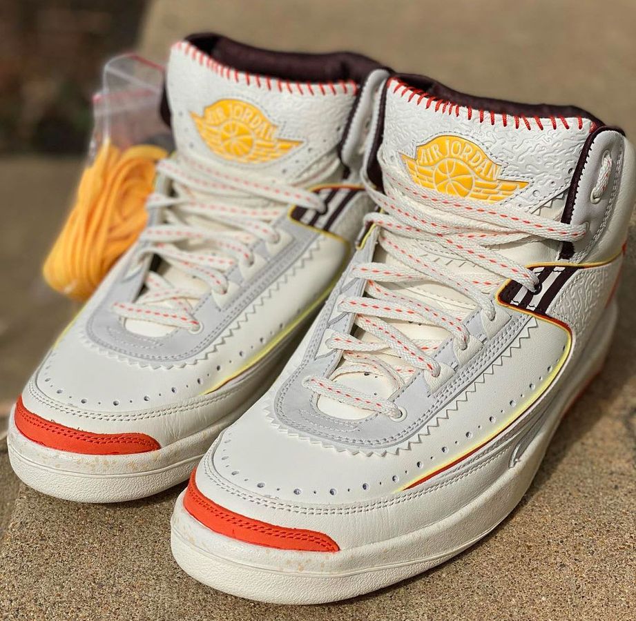 Air Jordan 2 x Maison Château Rouge product image of white and grey sneakers with orange and yellow accents.