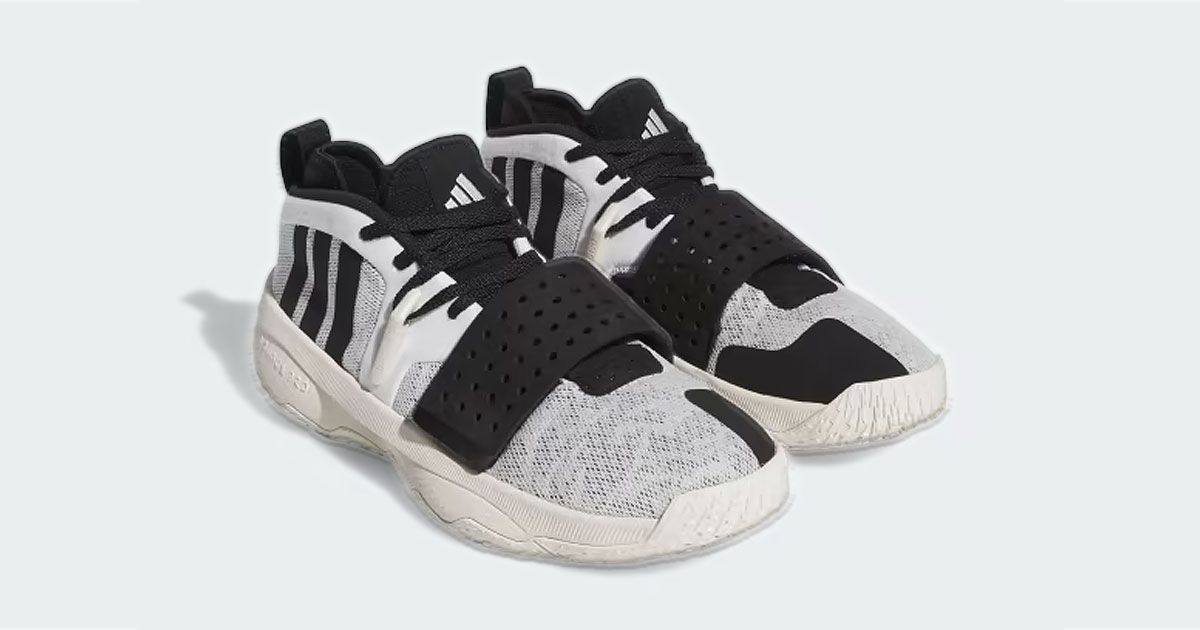 A pair of black and off-white adidas-branded basketball shoes with straps over the front.