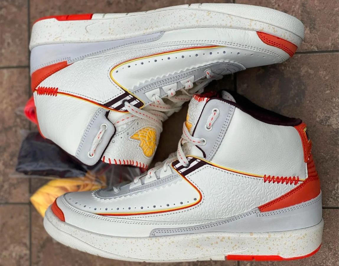 Air Jordan 2 x Maison Château Rouge product image of white and grey sneakers with orange and yellow accents.