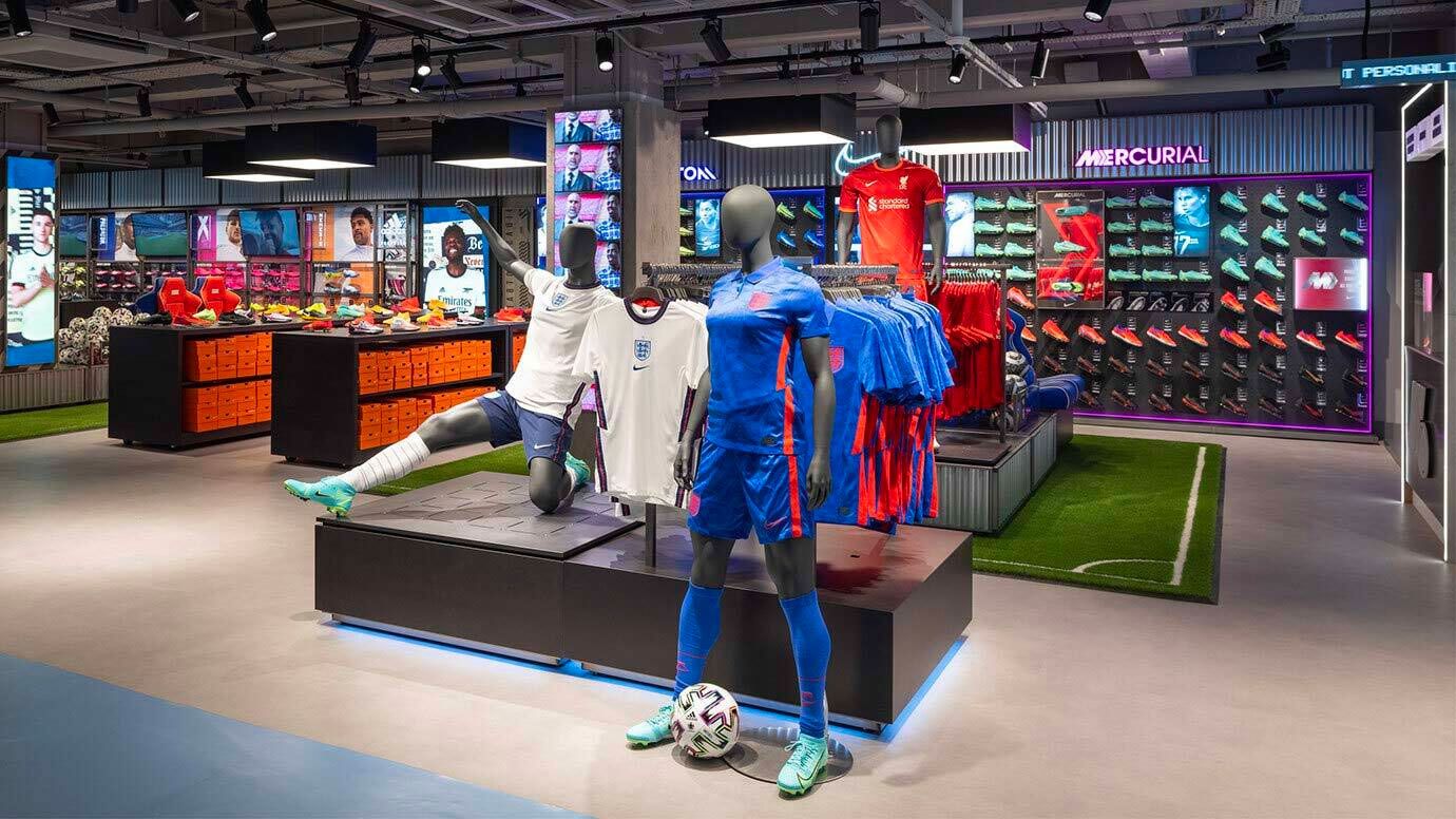 Picture of inside a SportsDirect store featuring mannequins wearing football kits and football boots on the walls.