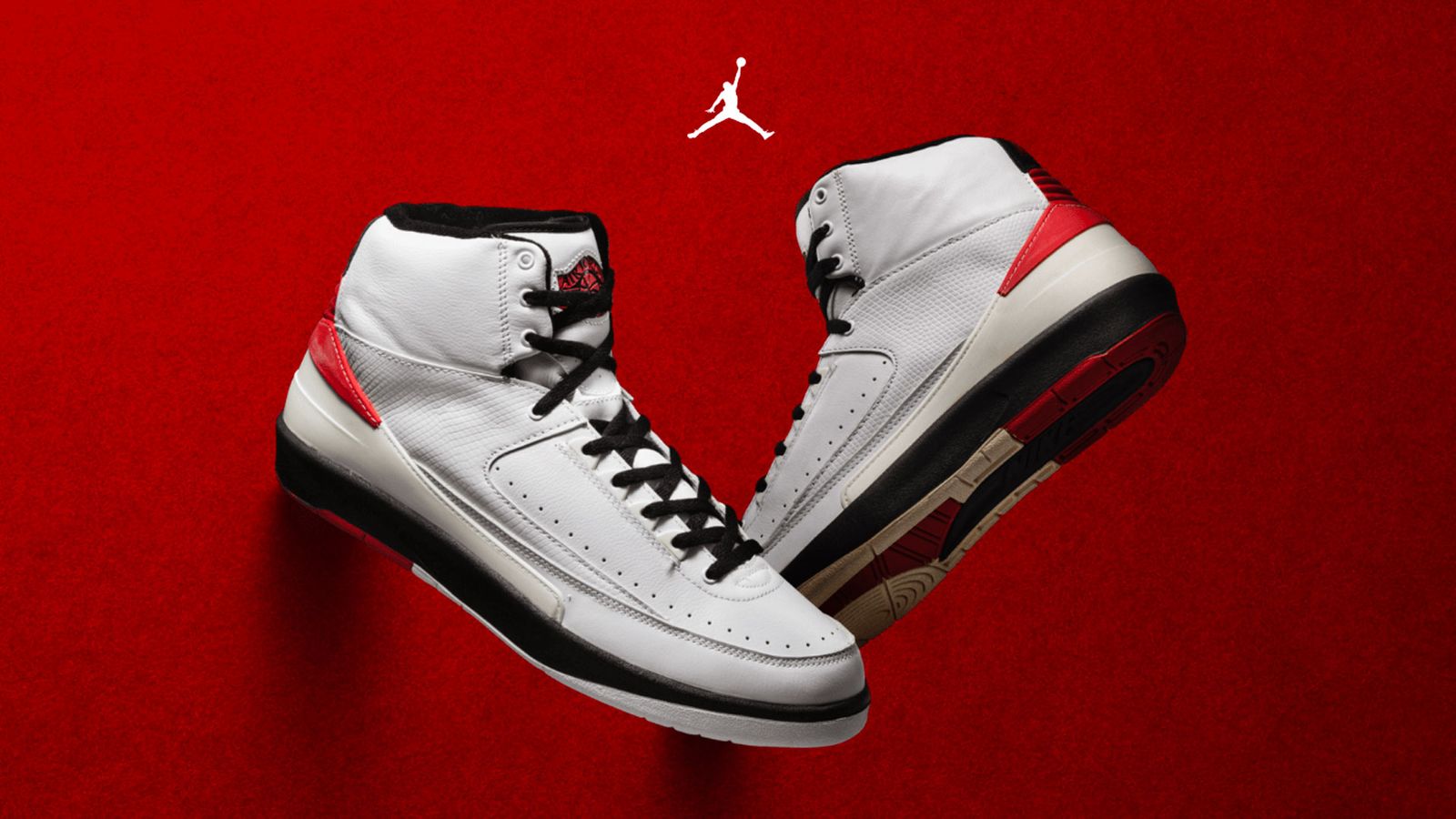 Air Jordan 2 "Chicago" product image of a pair of white, black, and red sneakers on a red background.