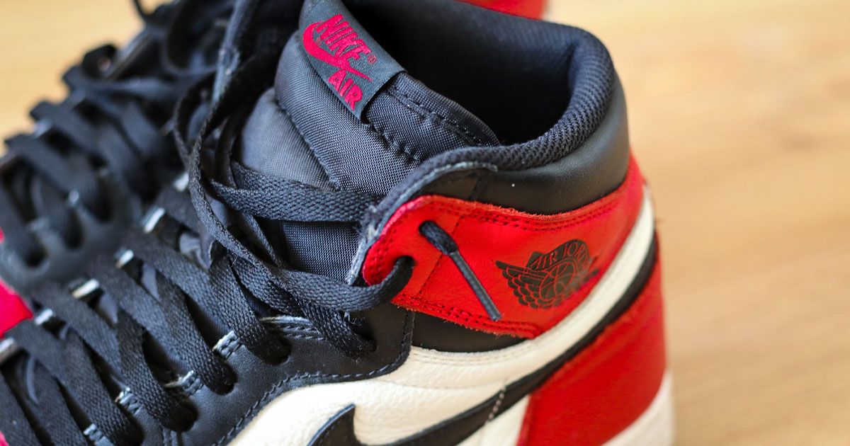 A close up of a pair of black, red, and white Air Jordan 1 sneakers.