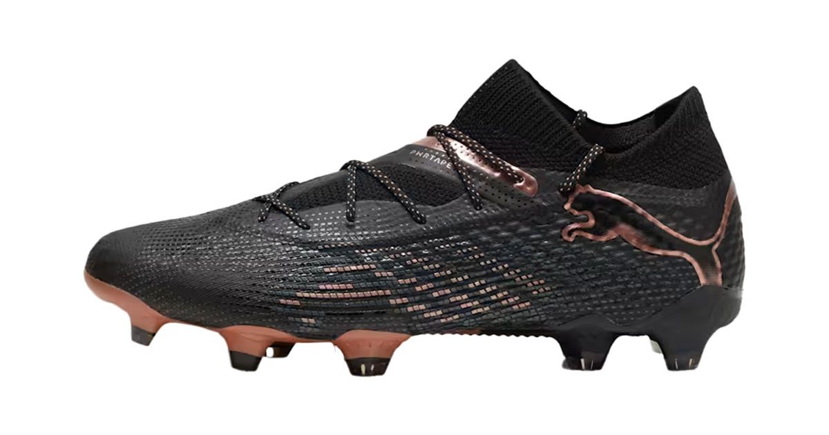 PUMA FUTURE 7 ULTIMATE product image of a black knitted football boot with metallic bronze trim and outlined PUMA branding around the heel.