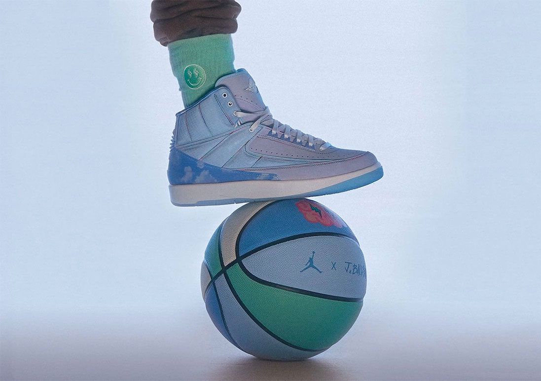 J Balvin x Air Jordan 2 product image of a light blue sneaker with sky blue overlays featuring cloudy graphics.