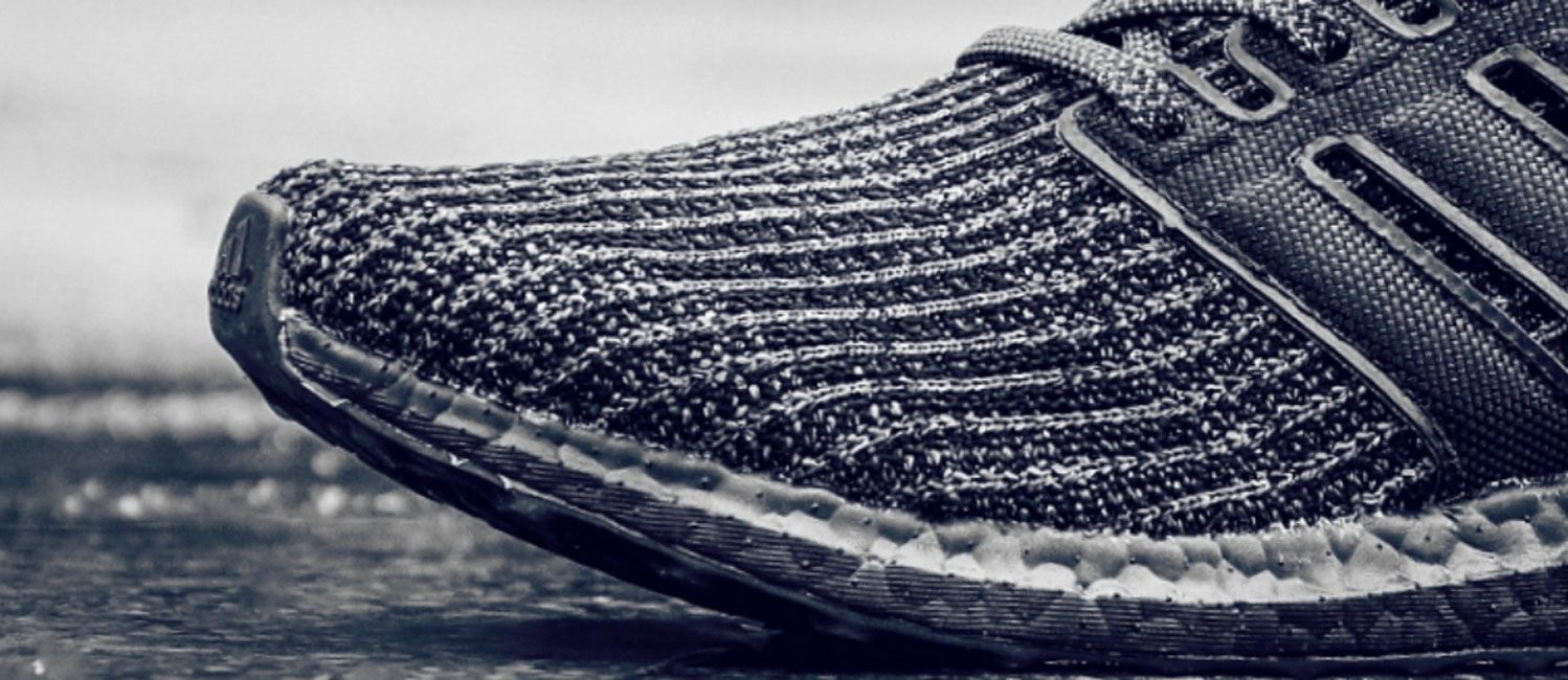 Adidas UltraBoost product image closeup shot of black Primeknit material.