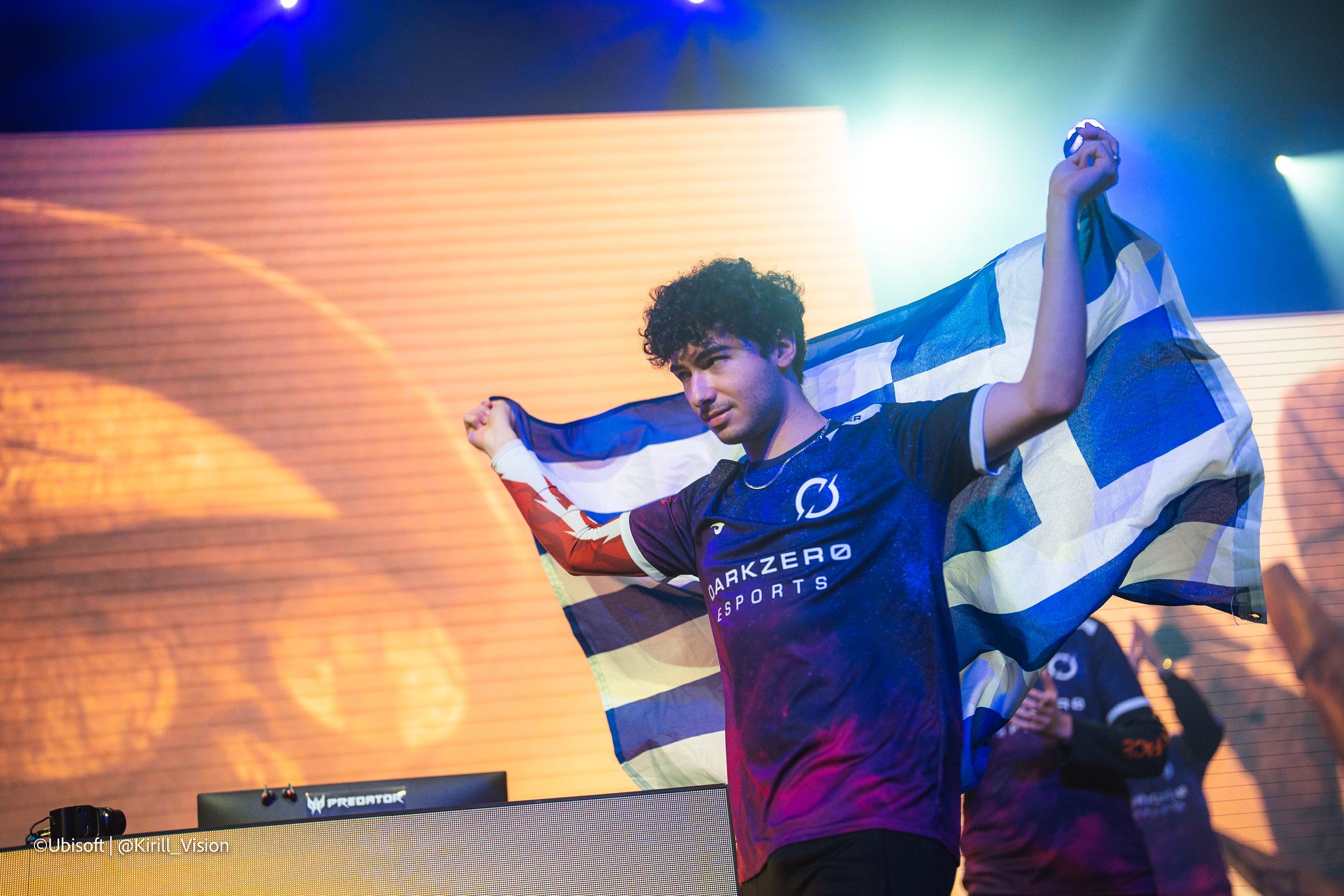 a man is holding a greek flag on a stage .