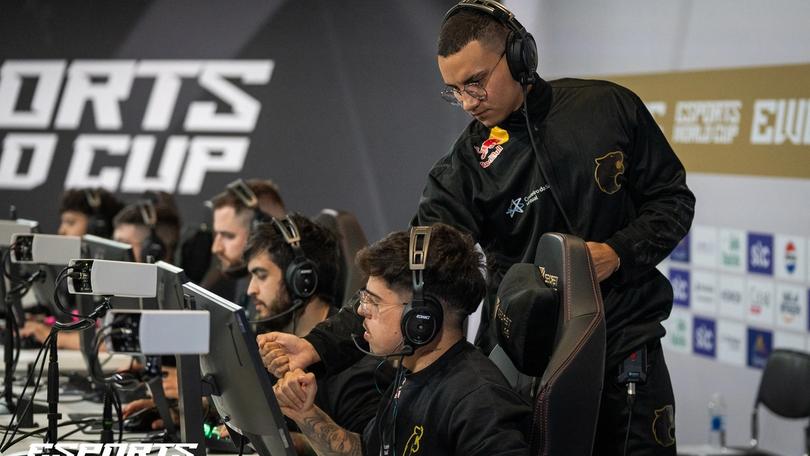 a group of men are sitting in front of computer monitors wearing headphones .