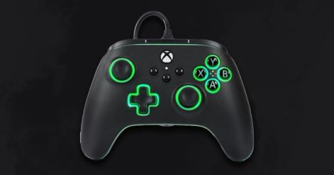 A black wired Xbox-branded controller with green lights around the buttons.