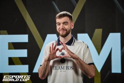 a man in a white shirt is making a heart with his hands .