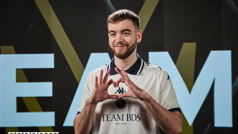 a man in a white shirt is making a heart with his hands .