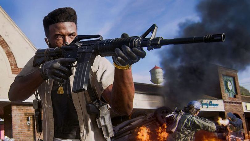 Black Ops 6 player aiming down sights of assault rifle with opponents fighting and burning building in background