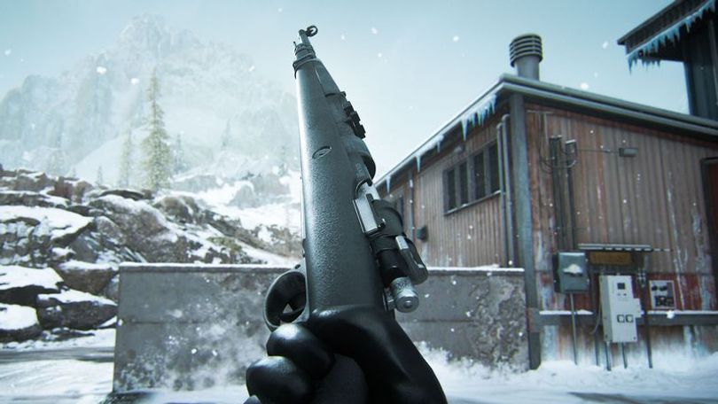 Warzone player holding a Kar98k marksman rifle with snow on rocks and a building in the background