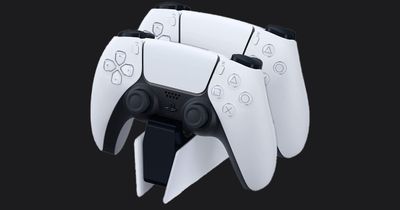 PlayStation DualSense Charging Station in white and black with two controllers attached.