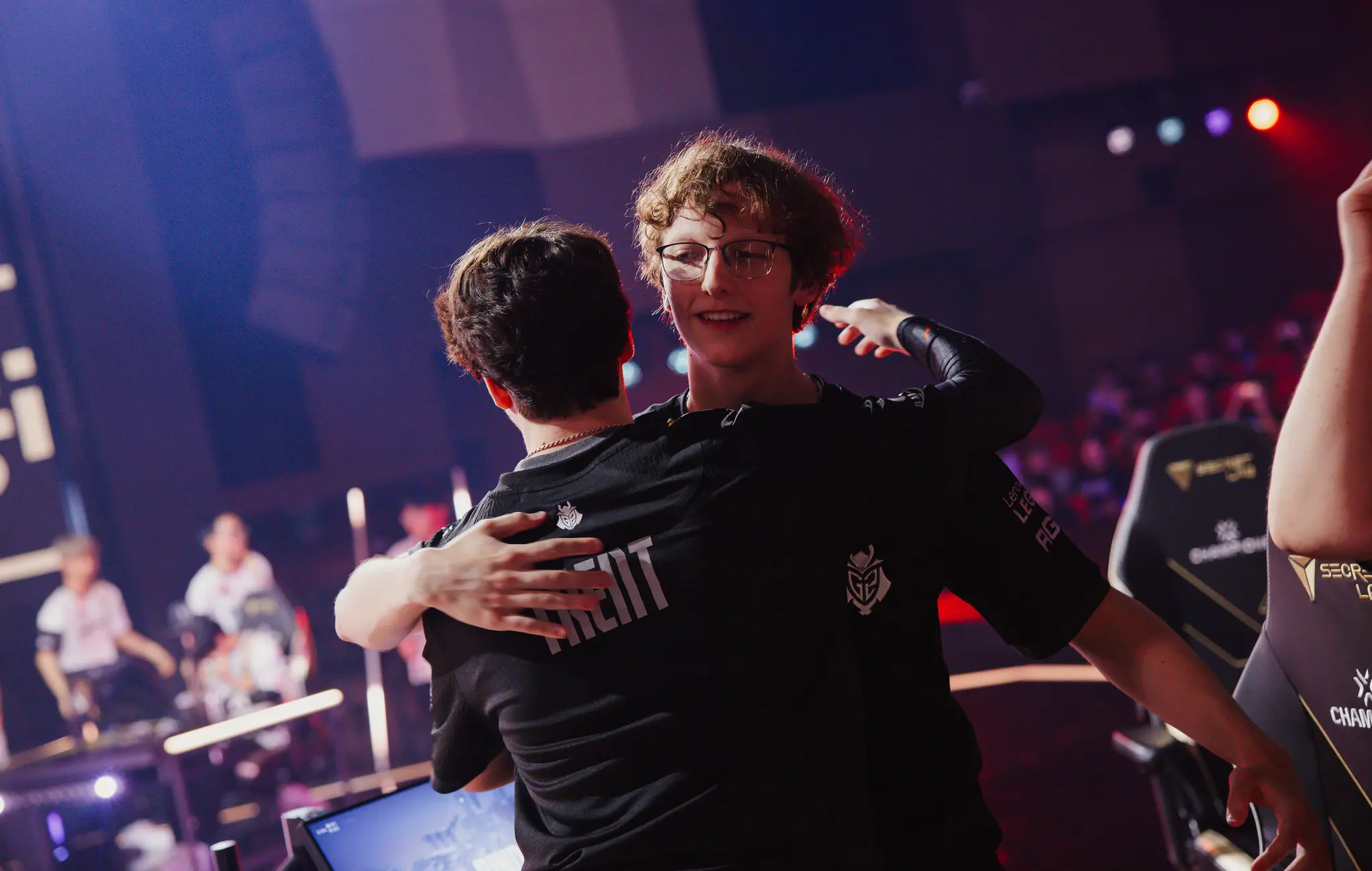 two men are hugging each other in a stadium .