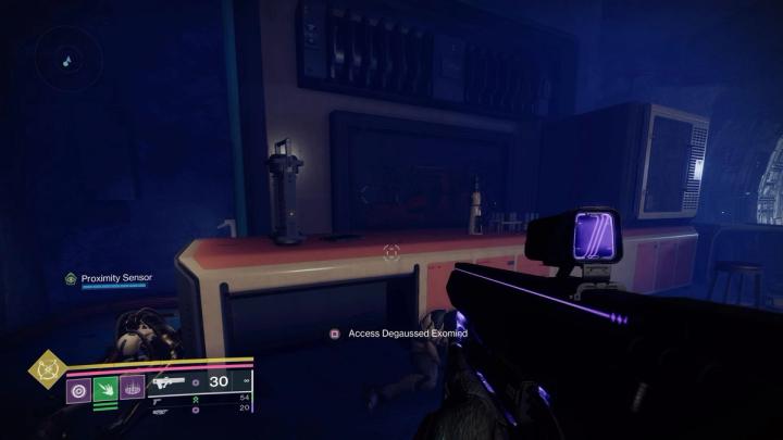 A first-person view of a Destiny 2 Guardian holding a weapon pointed at an empty desk with the prompt "Access Degaussed Exomind" on the screen