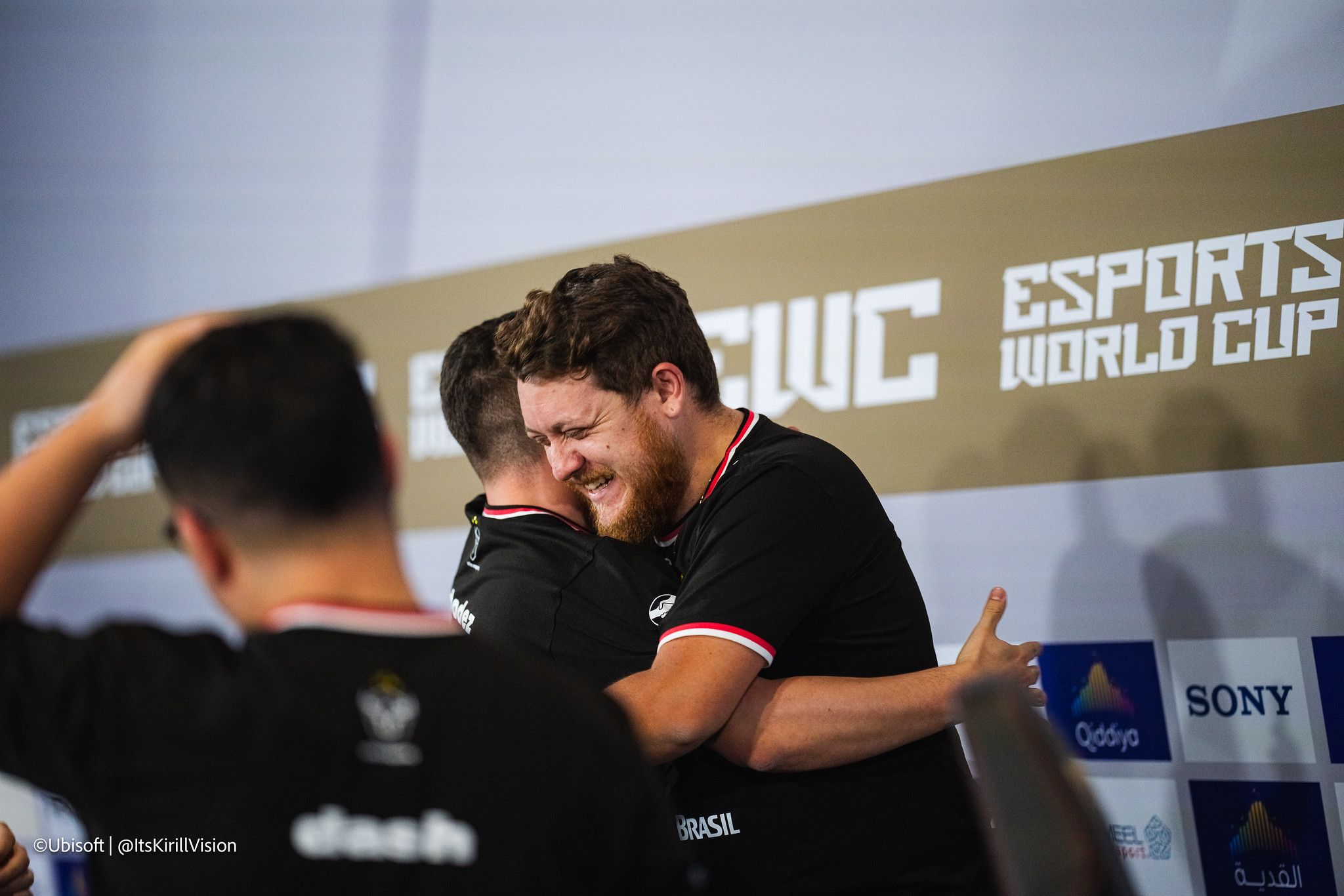 a group of men are hugging each other in front of a wall .