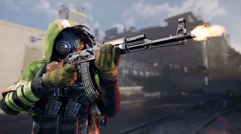 XDefiant key art shows a Cleaner character wearing a hi-vis hooded jacket and gasmask aiming and firing an assault rifle to the right.