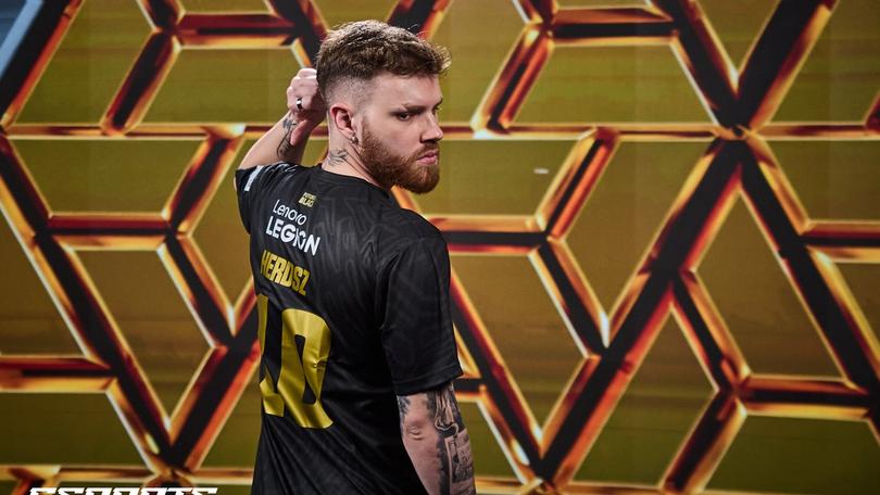 a man with a beard is standing in front of a gold wall .