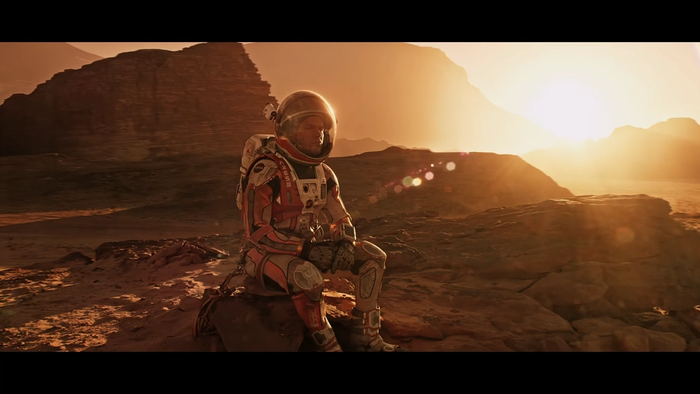 astronaut sits on a rock alone