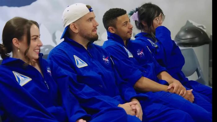 Four content creators in space training gear