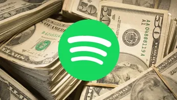 A pile of money behind the Spotify logo