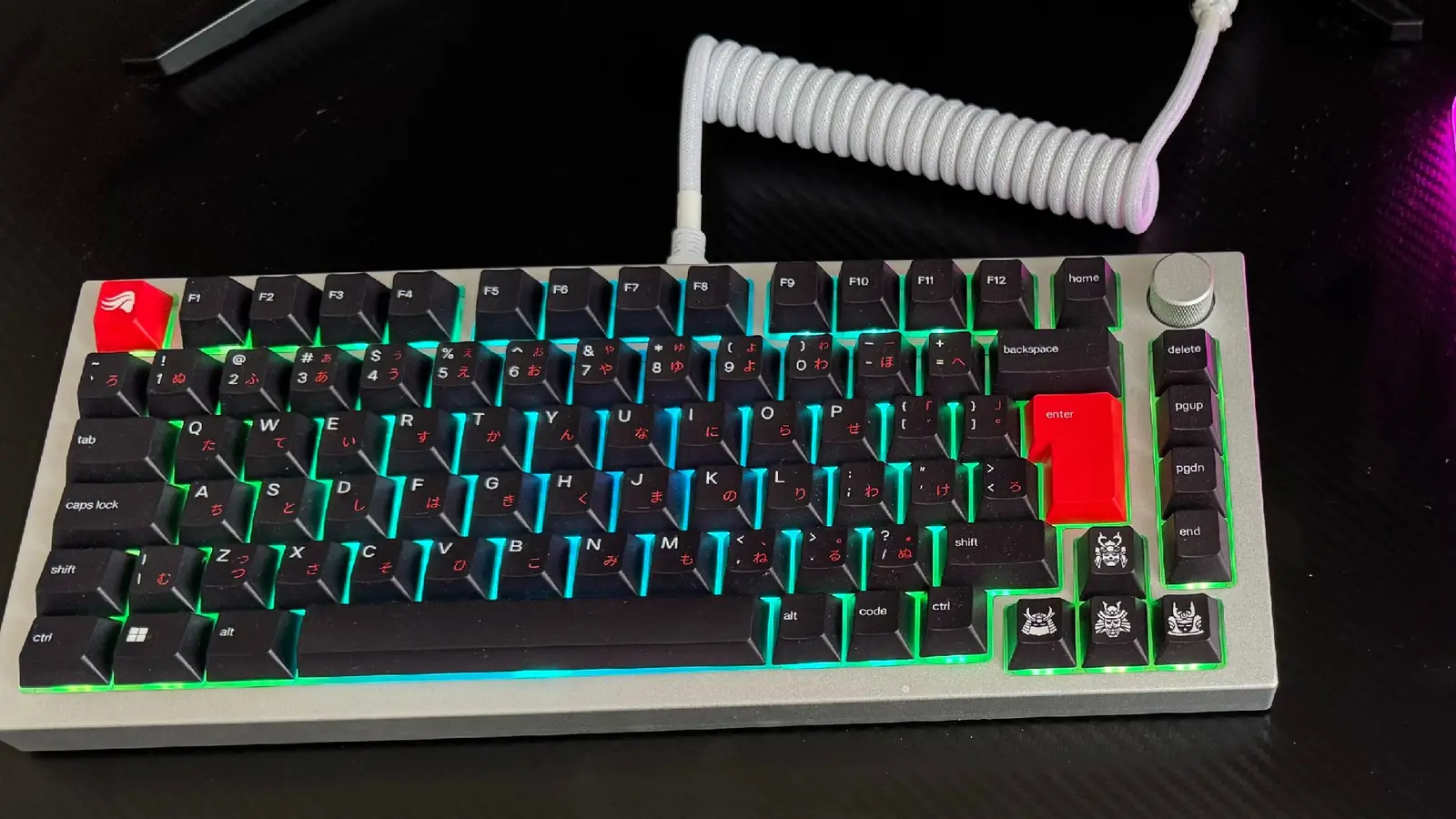 A custom GMMK Pro keyboard with Kabuto keys and a coiled white wire on a desk