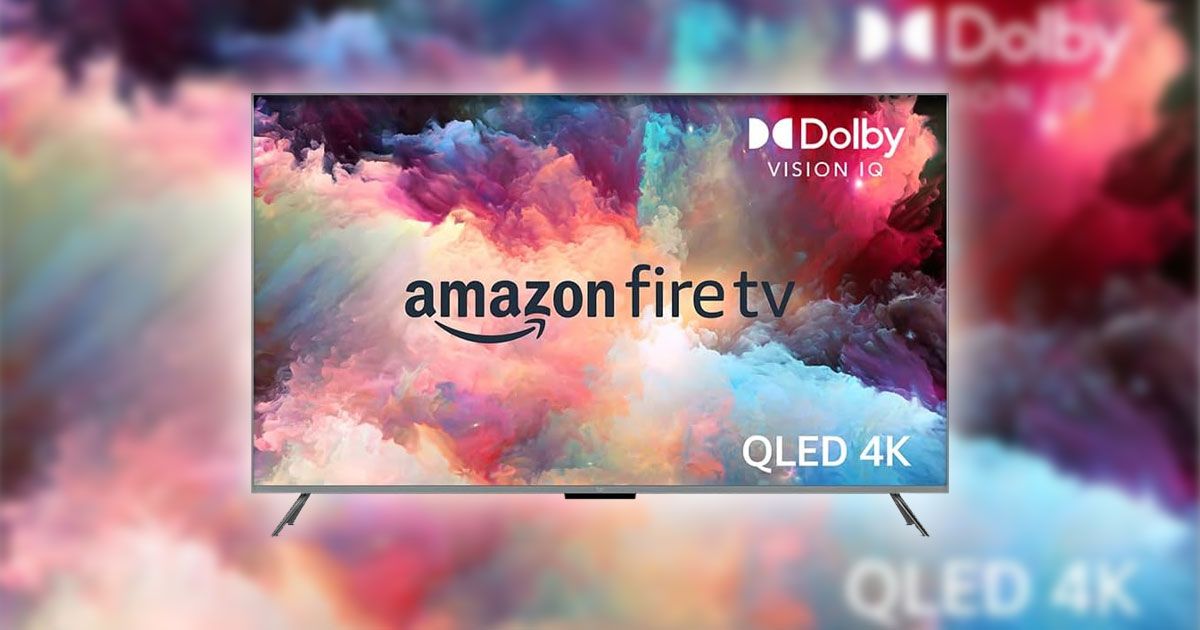 A flatscreen near-framless Amazon TV featuring multicolored smoke on the display matching the blurry background image.